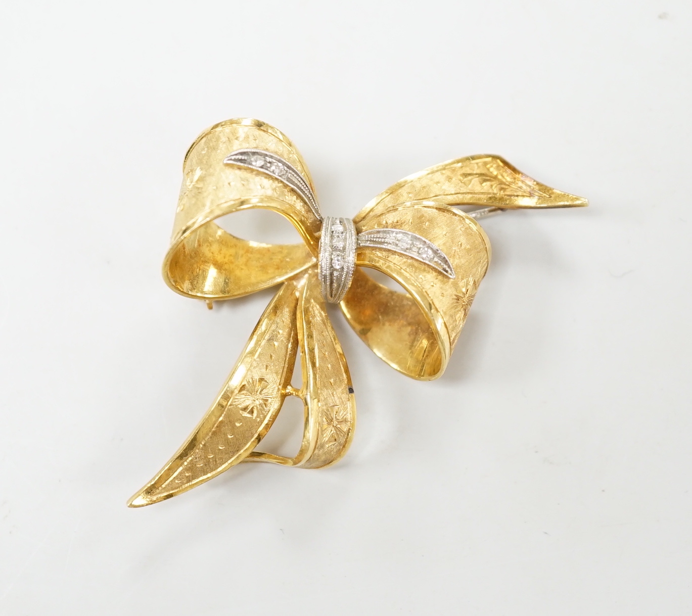 A 1970's 9ct gold and diamond chip set bow brooch, 51mm, gross weight 11.2 grams.